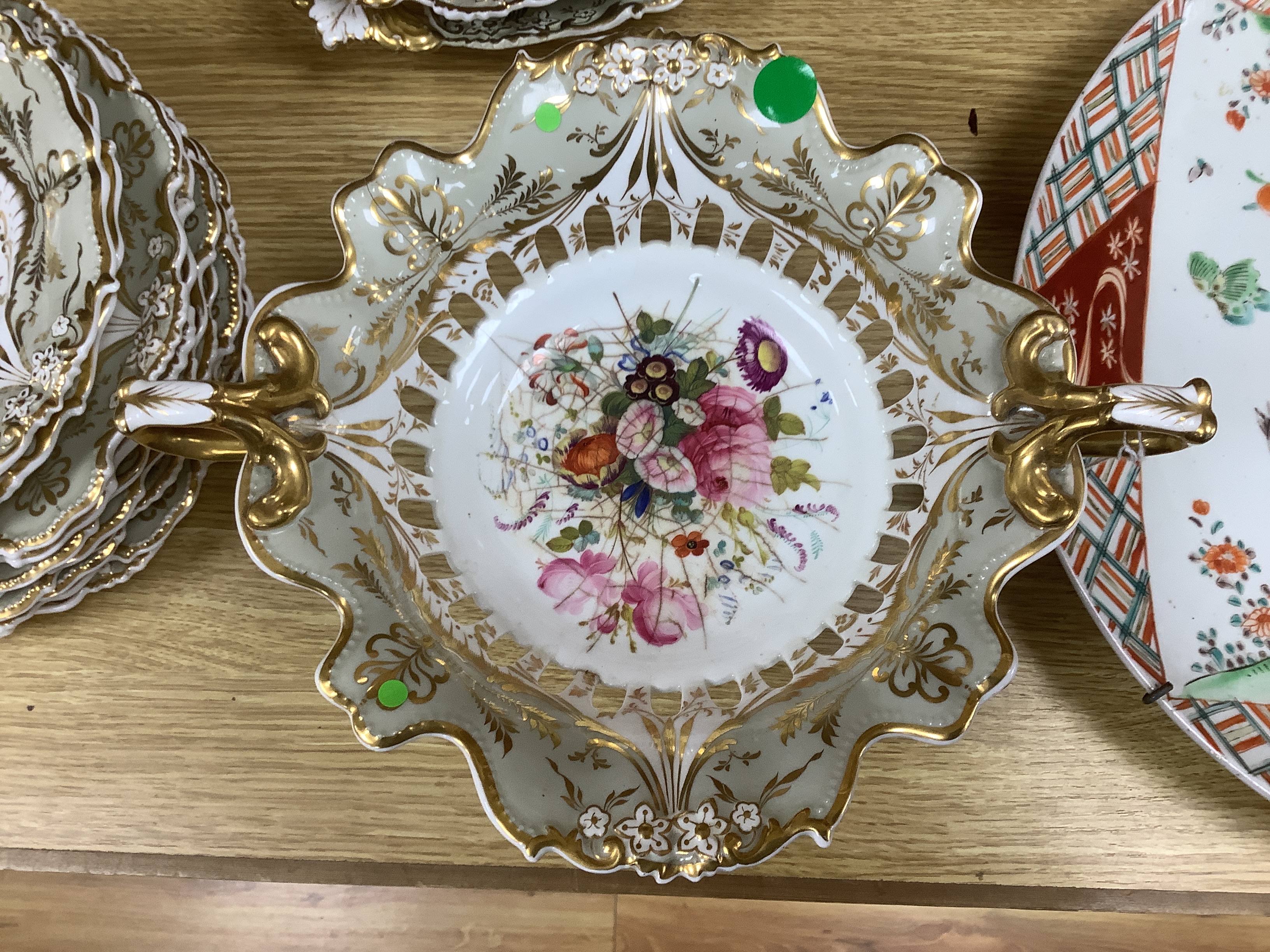 A Davenport porcelain part dessert service, each piece painted with a differing floral bouquet, within shaped grey and gilt borders